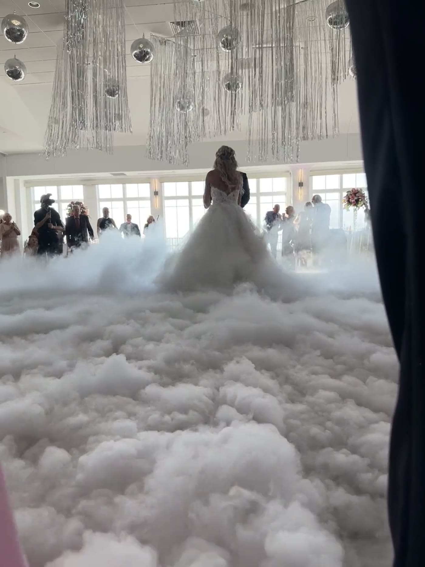 Bride and groom surrounded by DJ KYD dancing on the clouds first-dance effect